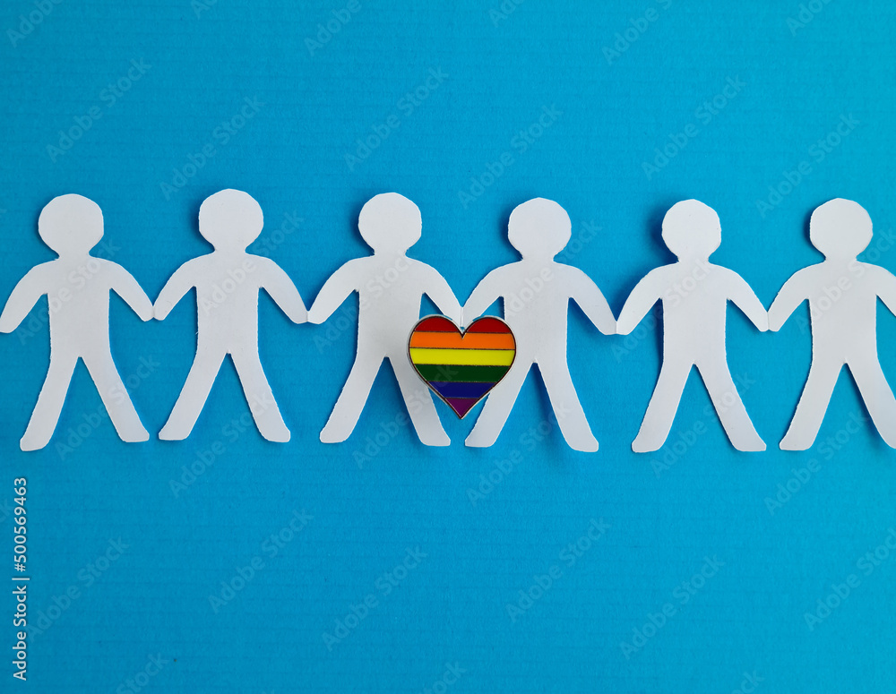 Paper figures holding hands on background of heart LGBT symbol Paper figures holding hands on background of heart LGBT symbol