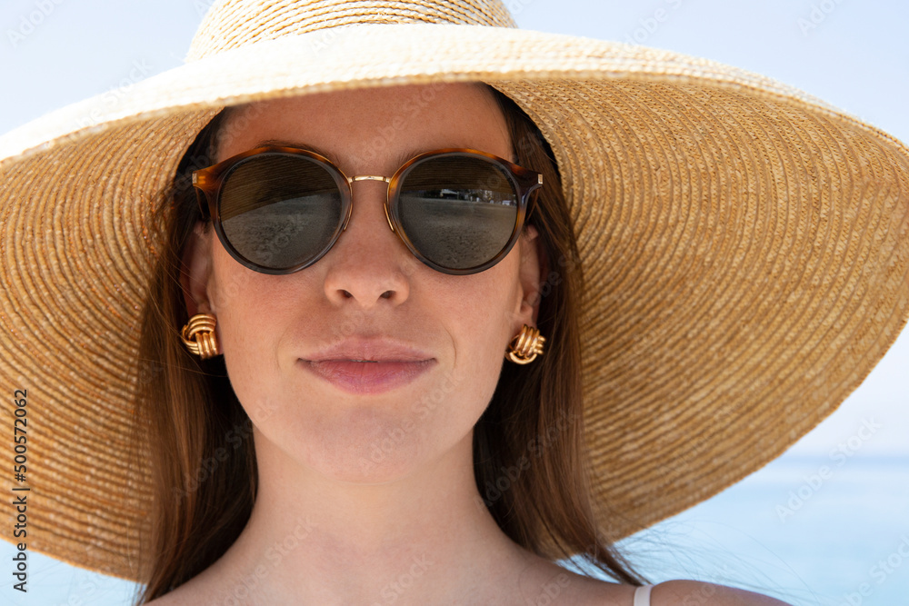 Portrait of a beautiful woman in beige bikini swimsuit putting on her ...