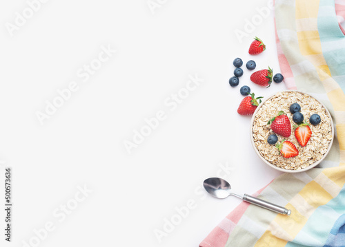 culinary background with oatmeal and berries in a plate and spoon