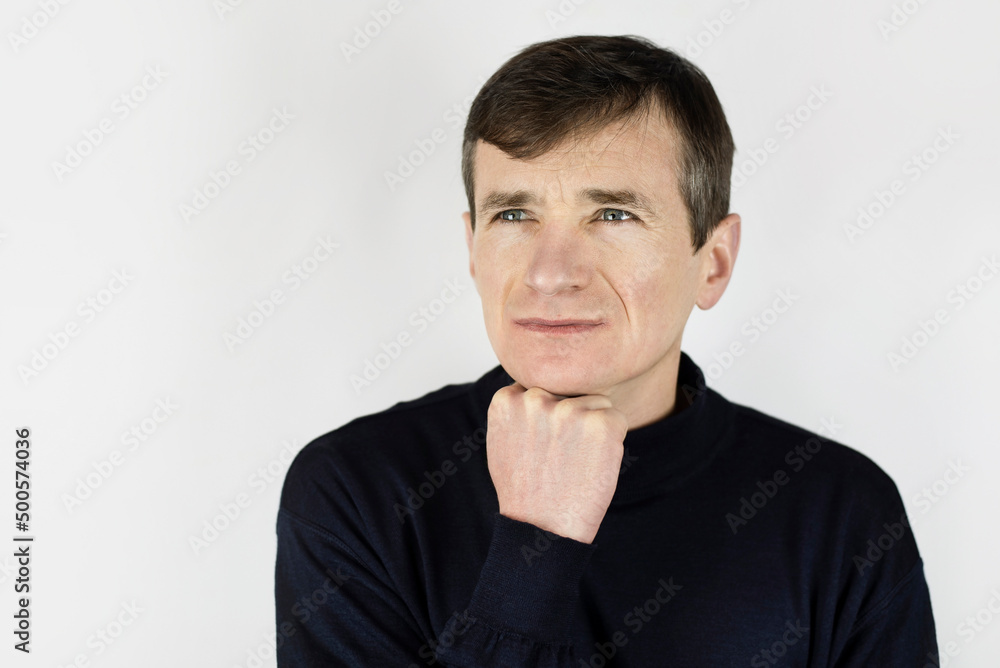 A middle-aged man looks anxiously to the future, he is experiencing a midlife crisis. Sad slender man on a light background looking away A middle-aged man looks anxiously to the future, he is experiencing a midlife crisis. Sad slender man on a light background looking away