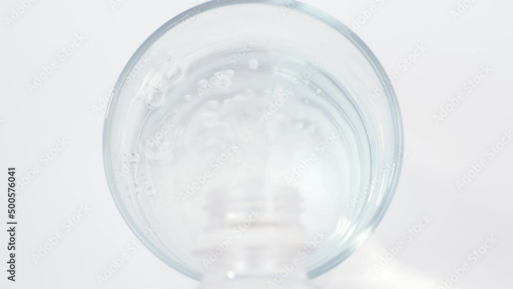 Pouring water from a bottle into a glass and throwing soluble effervescent tablet of medicament or vitamin Pouring water from a bottle into a glass and throwing soluble effervescent tablet of medicament or vitamin