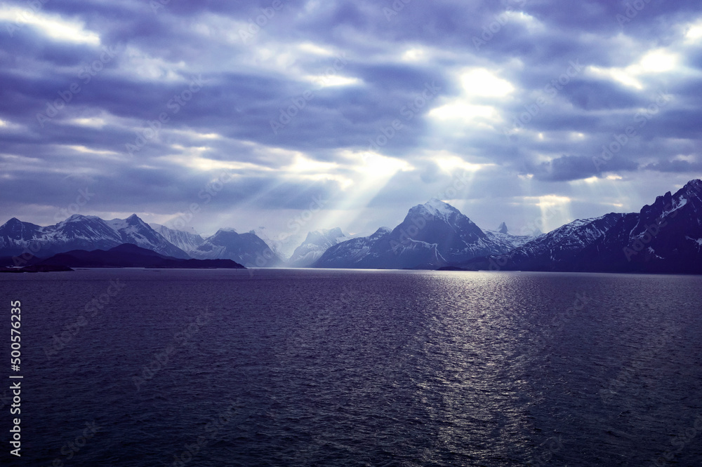 Dark moody sky with light rays over the coast of Norway