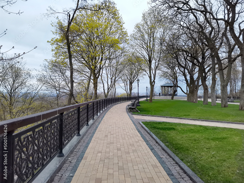 Fototapeta premium Volodymyrska Hill park road with benches and gazebo in Kyiv, Ukraine on a spring day