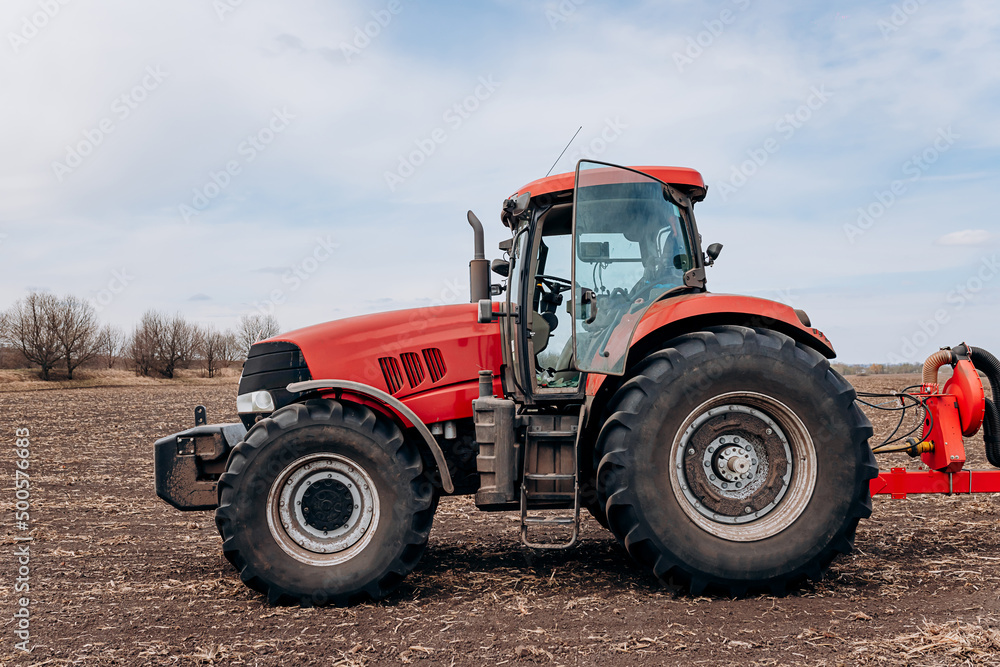 Spring sowing season. Farmer with a tractor sows corn seeds on his field. Planting corn with trailed planter. Farming seeding. The concept of agriculture and agricultural machinery. Spring sowing season. Farmer with a tractor sows corn seeds on his field. Planting corn with trailed planter. Farming seeding. The concept of agriculture and agricultural machinery.