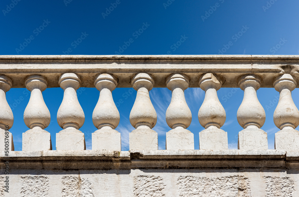 Fototapeta premium Close-up of a white marble balustrade in classical style against a clear blue sky and copy space. Brescia downtown, Lombardy, Italy, Europe.