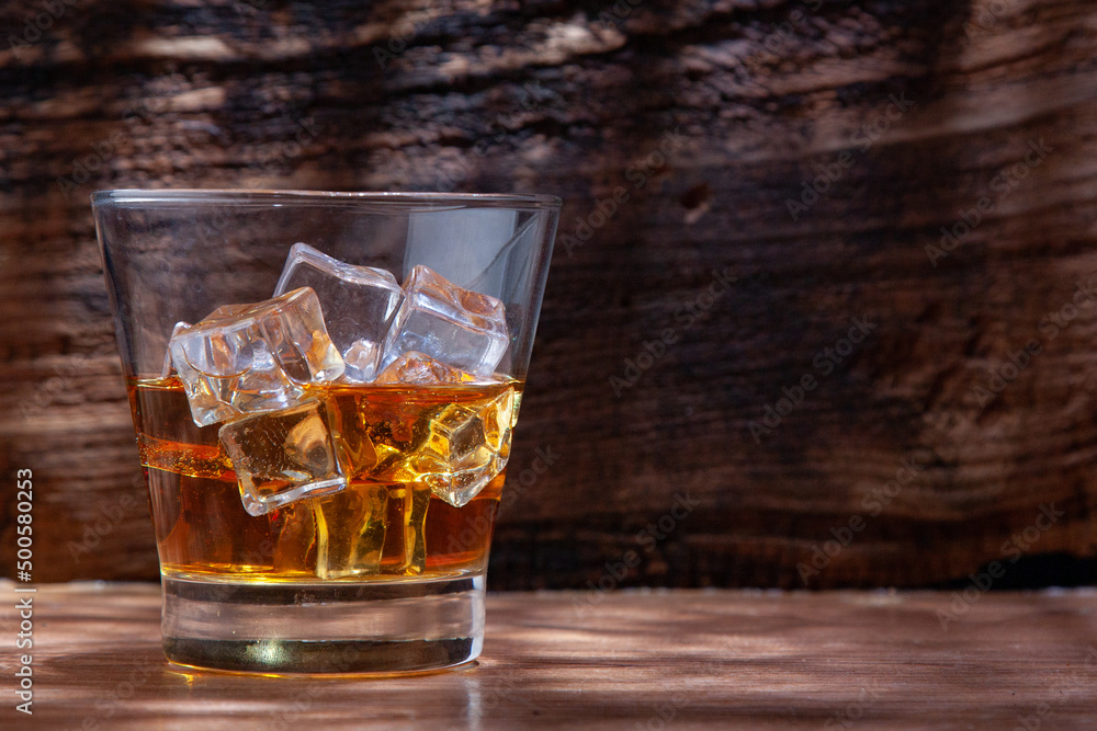 Whiskey or alcoholic beverages or bourbon with ice on the wooden floor and a black and white scene with a top view Whiskey or alcoholic beverages or bourbon with ice on the wooden floor and a black and white scene with a top view
