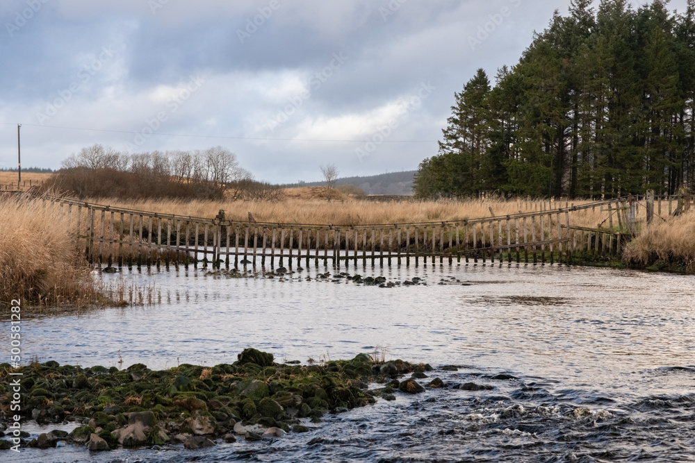 A watergate hanging across the Carsphairn Lane River at the Water of Deugh