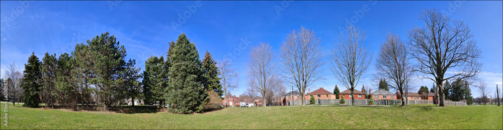 Panoramic web banner of the public park in a residential district. Tranquillity scene of a panoramic view of the park in spring. Panoramic web banner of the public park in a residential district. Tranquillity scene of a panoramic view of the park in spring.