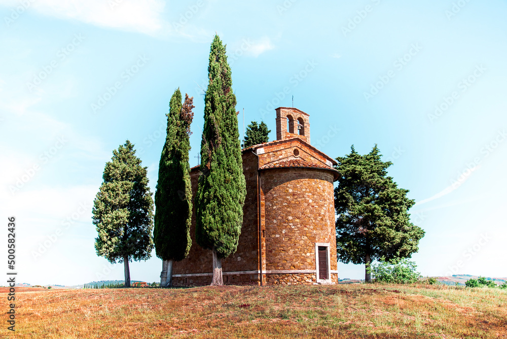 Tuscany, Italy, May, 2017: Magic landscape with chapel of Madonna di Vitaleta on a sunny day in San Quirico d'Orcia (Val d'Orcia) in Tuscany, Italy. Excellent tourist places.
