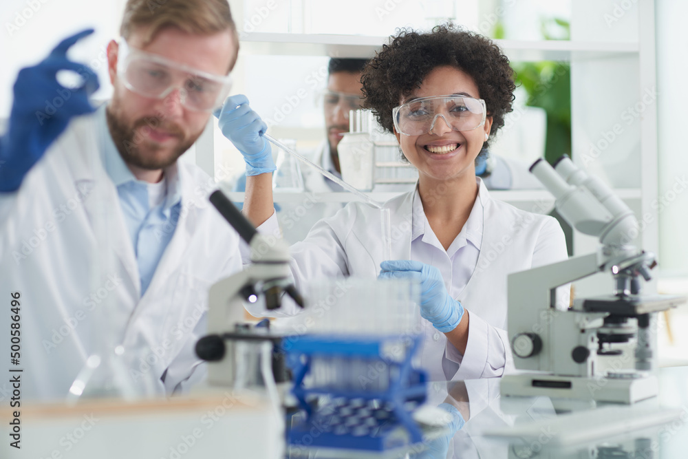 Smiling scientists looking at camera arms crossed in laboratory Smiling scientists looking at camera arms crossed in laboratory
