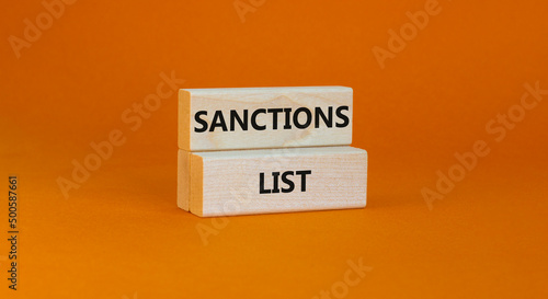 Sanctions list symbol. Wooden blocks with concept words Sanctions list on beautiful orange background. Business political sanctions list concept. Copy space.