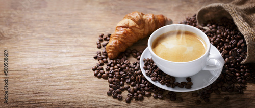 Canvas cup of coffee, croissant and coffee beans