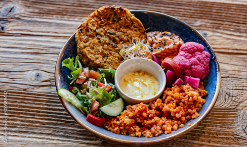 Vegan plate with millet cutlet, bulgur groats and vegetables