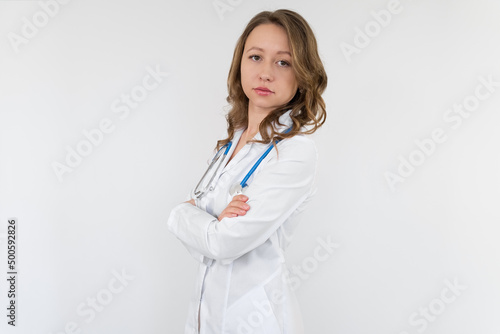 A nurse girl in a medical gown with a stethoscope around her neck and hands crossed on her stomach