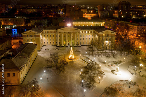 Aerial view of Oblast Duma building with Christmas tree in front of it on polar night. Murmansk, Russia.