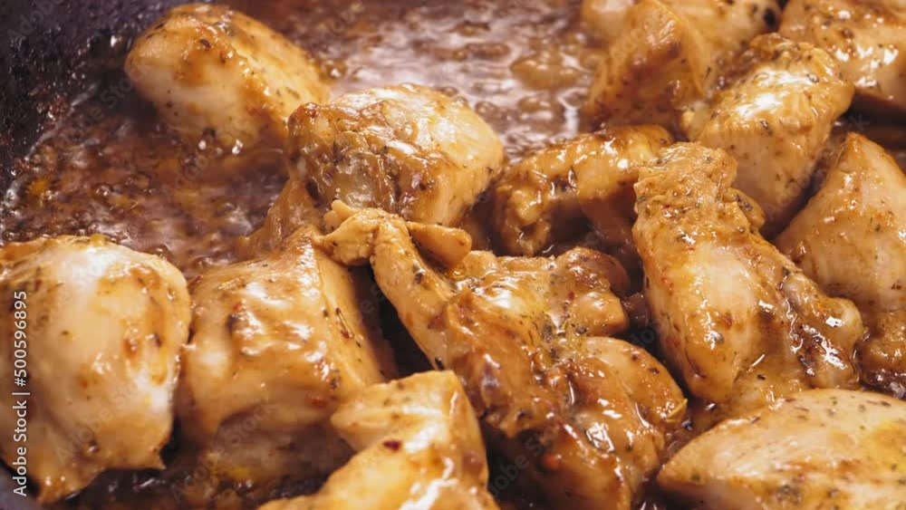pieces of chicken in spices fried in a frying pan. Close-up pieces of chicken in spices fried in a frying pan. Close-up