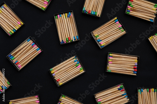 multicolored match sticks in boxes on a black background