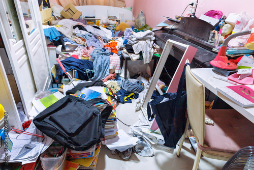 A room cluttered with piles of clothes photo