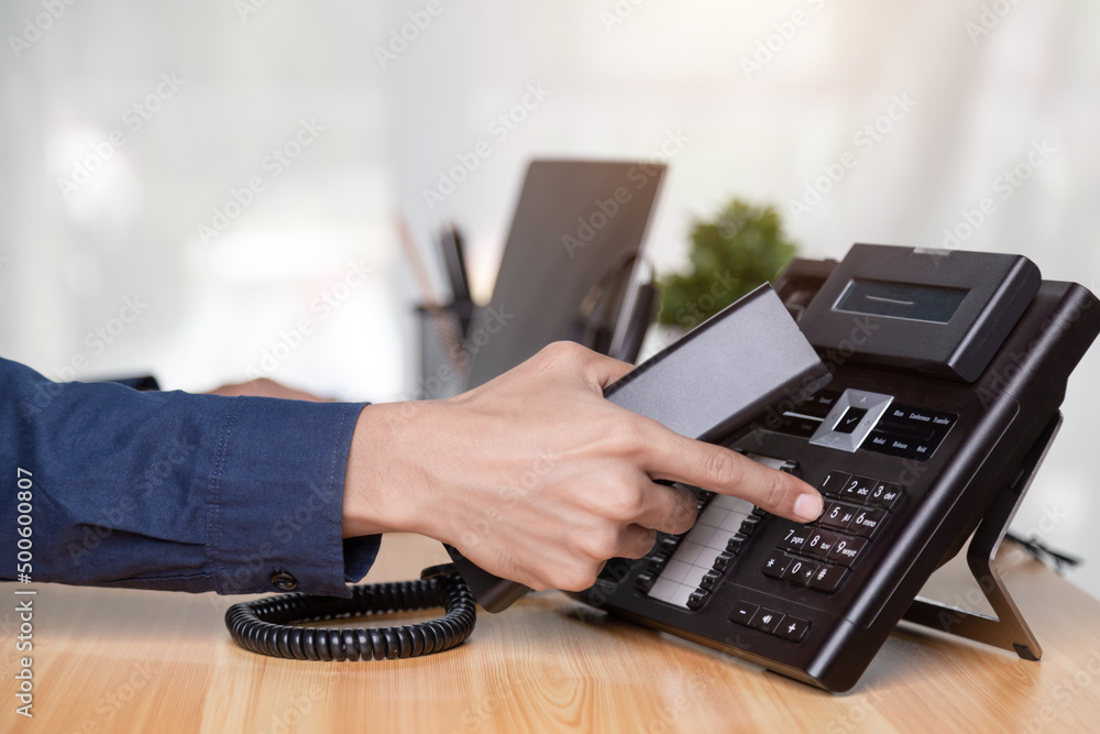 Call center staff man hand point to press the button number on the phone office desk , Communication support, call center and customer service help desk. for (call center) concept Call center staff man hand point to press the button number on the phone office desk , Communication support, call center and customer service help desk. for (call center) concept