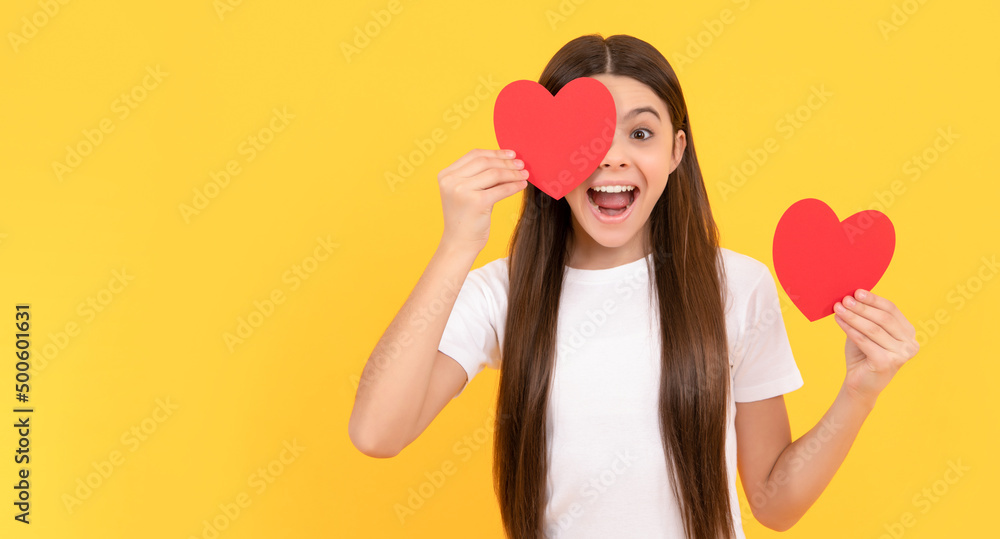 surprised teen girl holding valentines heart on yellow background, love day surprised teen girl holding valentines heart on yellow background, love day