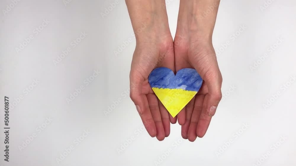 Hand holding a heart made from the flag of Ukraine blue yellow on an isolated white background. Concept of victory of Ukraine, independence of Ukraine. Patriotism and love for the country. My homeland Hand holding a heart made from the flag of Ukraine blue yellow on an isolated white background. Concept of victory of Ukraine, independence of Ukraine. Patriotism and love for the country. My homeland