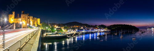 Conwy, Wales - Panorama of Conwy Castle and harbour by night photo
