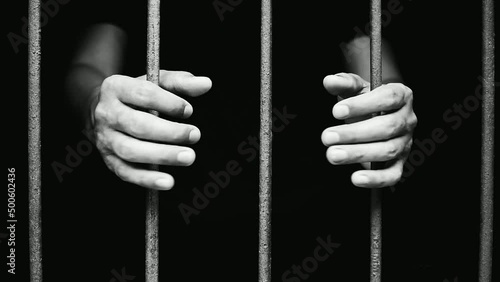 hand man hold steel in jail on black background.concept for prisoner,sadness,detain,erroneousness