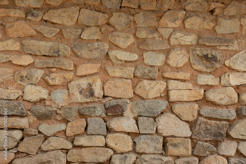 A stone wall texture found on the side of the road.