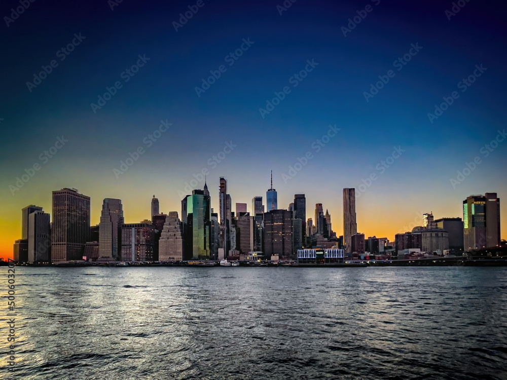 Fototapeta premium Panoramic view of beautiful sunset and colorful sky with Manhattan skyline in New York City.
