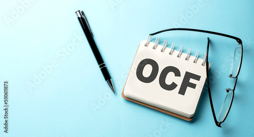 OCE text written on a notepad on the blue background photo