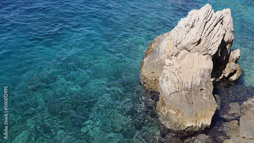 Rock and sea on a sunny day, seascape. Picturesque stone against the background of the turquoise blue water of the Adriatic Sea
