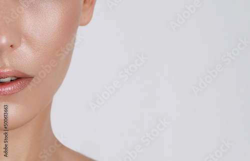 woman's face close-up with cheekbone and lips, macro on a white background, shiny fresh skin, beauty