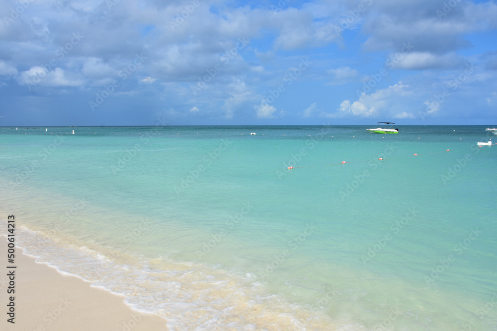 Obraz premium Waves Gently Lapping the Shore of Palm Beach Aruba
