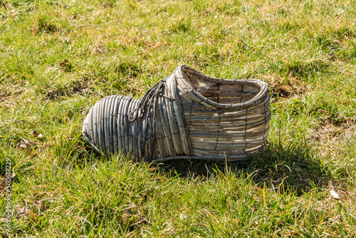 Unusual shoe made of woven twigs to decorate the garden or yard.