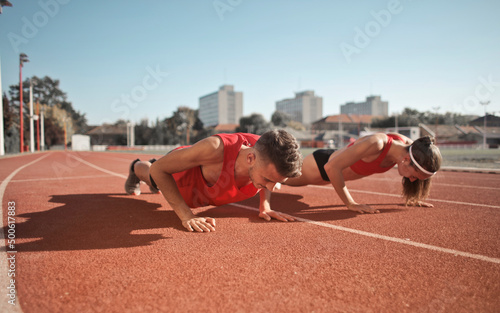 Foto two young boys do push-ups to train on a track