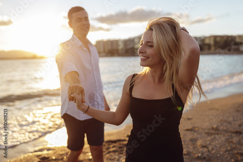 Smiling lady wearing black dress standing by the sea with man