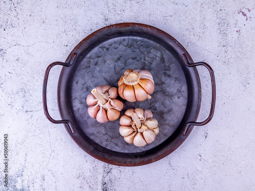Heads of fresh garlic on vintage metal tray