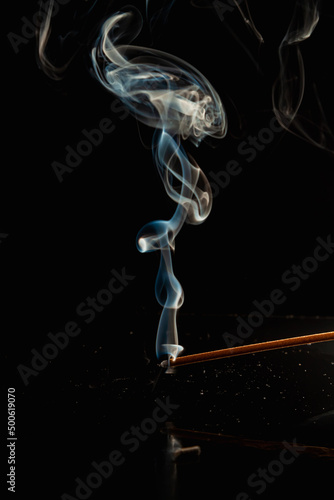 Quadro em tela Blue wisp of smoke on black background.