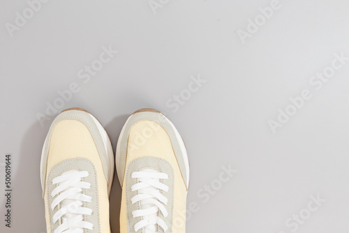 classic light color sneakers on grey background
