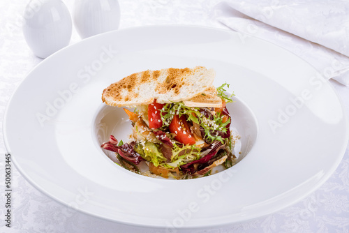 Salad with seafood and vegetables on a white plate