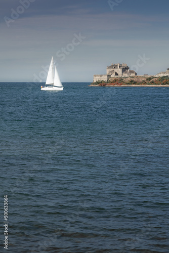 Yacht sailing towards sunset in blue background,