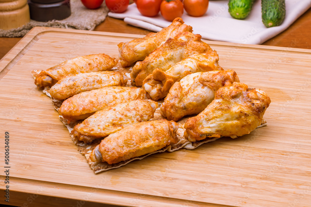 chicken wings kebab on wooden board macro close up