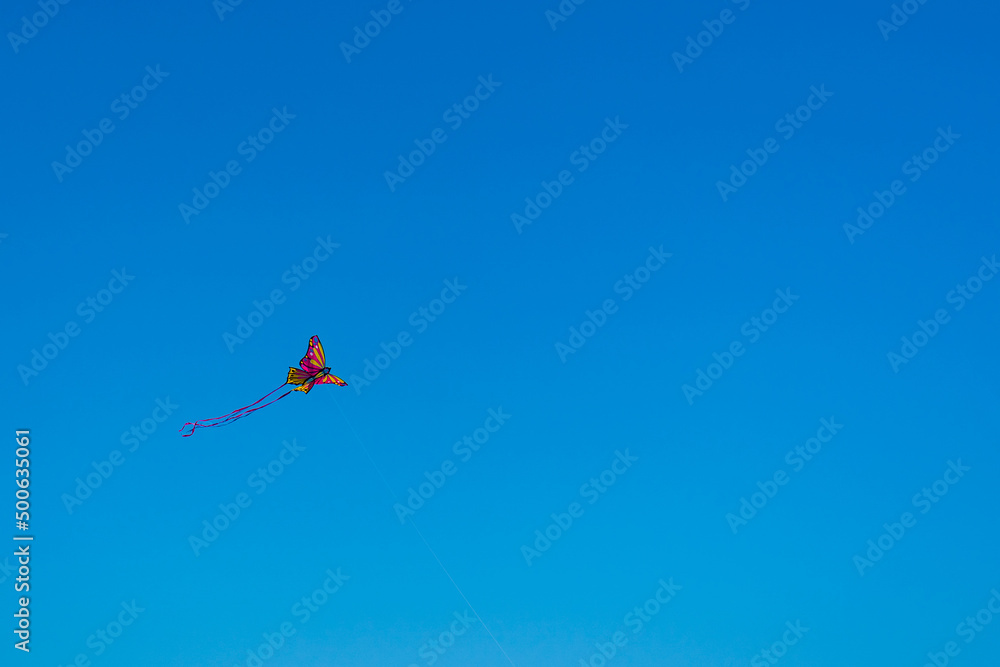 volar una mariposa con forma de cometa en el cielo azul de la playa en el mar de oropesa españa volar una mariposa con forma de cometa en el cielo azul de la playa en el mar de oropesa españa
