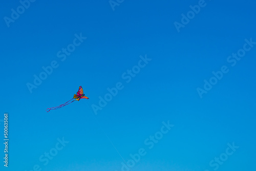 volar una mariposa con forma de cometa en el cielo azul de la playa en el mar de oropesa españa