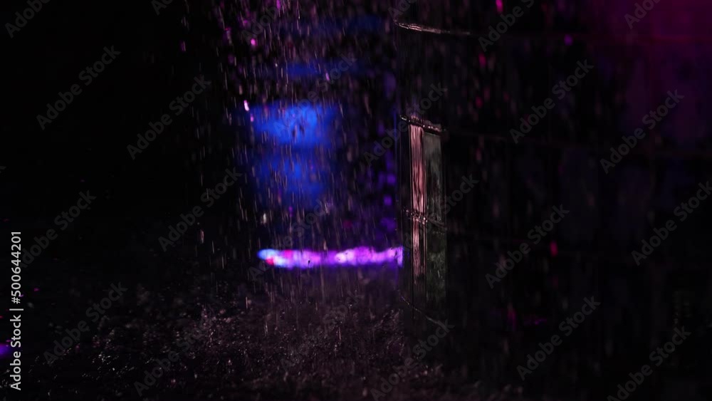 Water falling and dripping off fountain at night in slow motion while lights shift color in the background Water falling and dripping off fountain at night in slow motion while lights shift color in the background