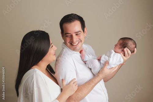 PARENTS HOLDING A NEWBORN BABY