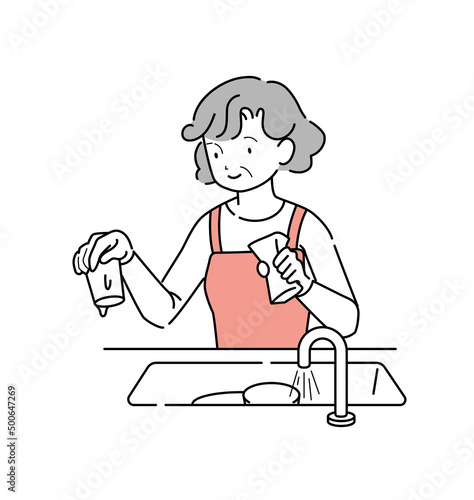 シンクの中の食器を洗う年輩女性