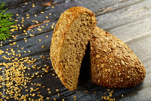 Homemade oven fresh multigrain brown crusted bread loaf on a rustic kitchen table background.