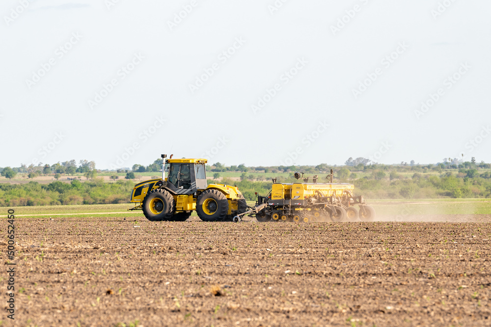 Obraz premium tractor plowing the land for sowing