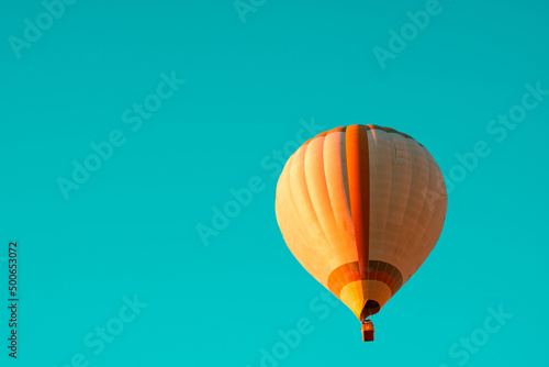 Hot air balloon isolated on turquoise background.